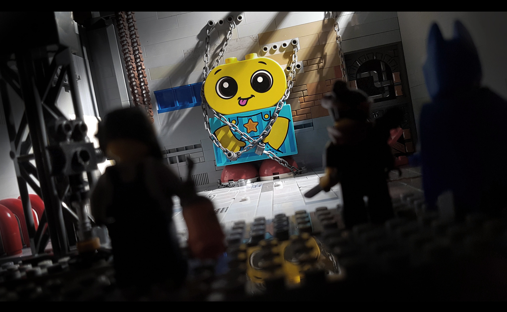 Photo of LEGO Duplo character chained to a wall with The LEGO Movie characters in foreground by Shannon Sproule