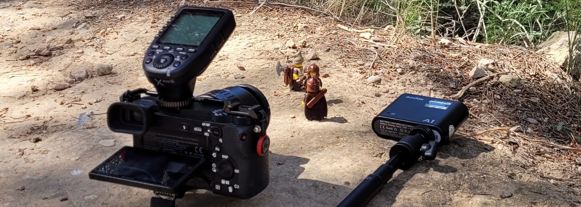 Behind the scenes of a LEGO photography session with camera, flash, and LEGO minifigures