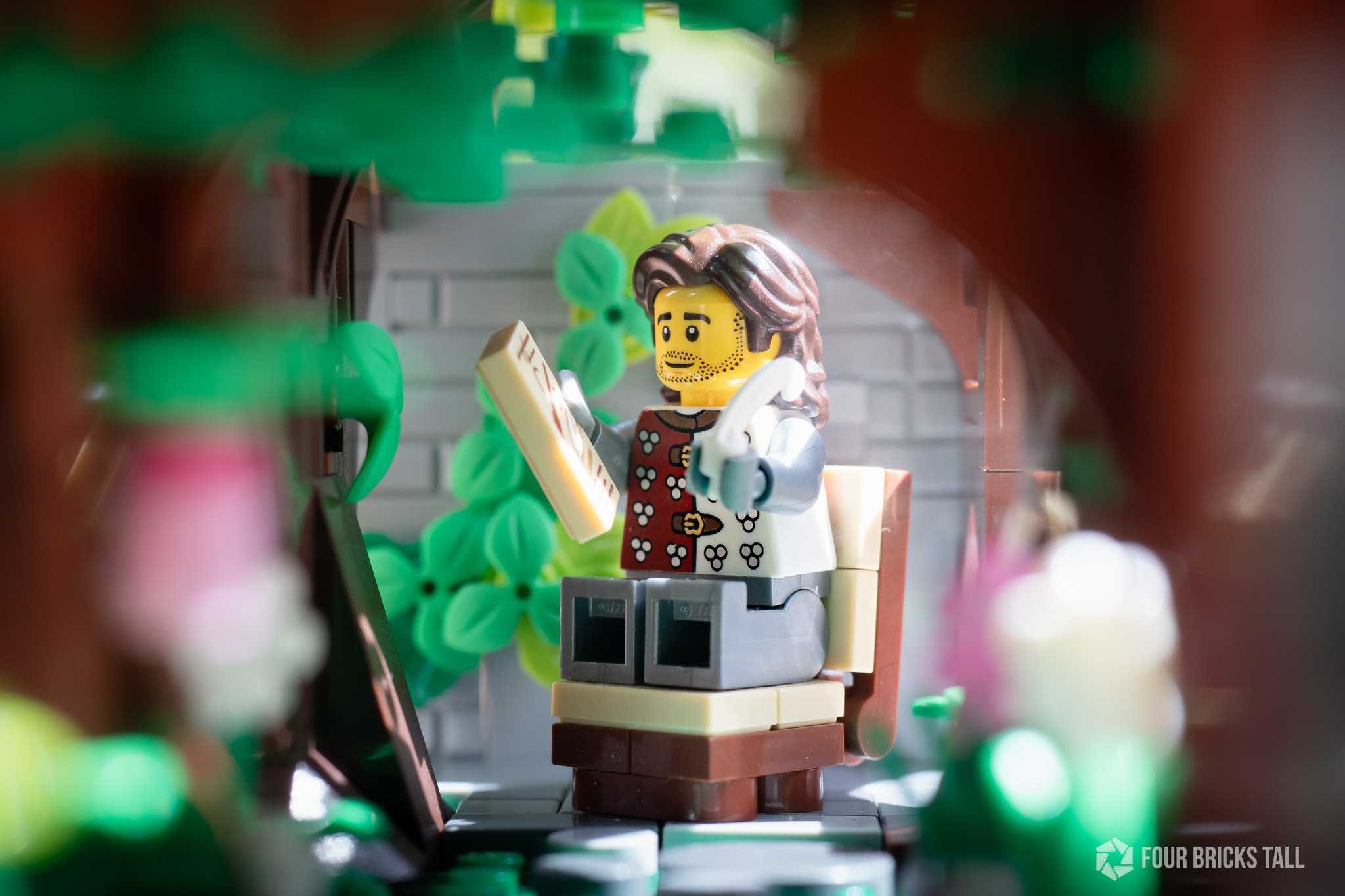 Photo of LEGO medieval knight writing with a plume inside in a garden