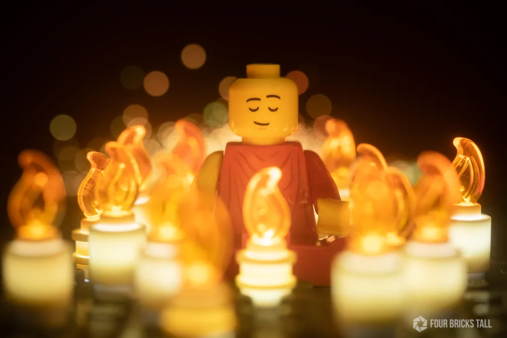 Photo of LEGO minifigure monk sitting among lit candles